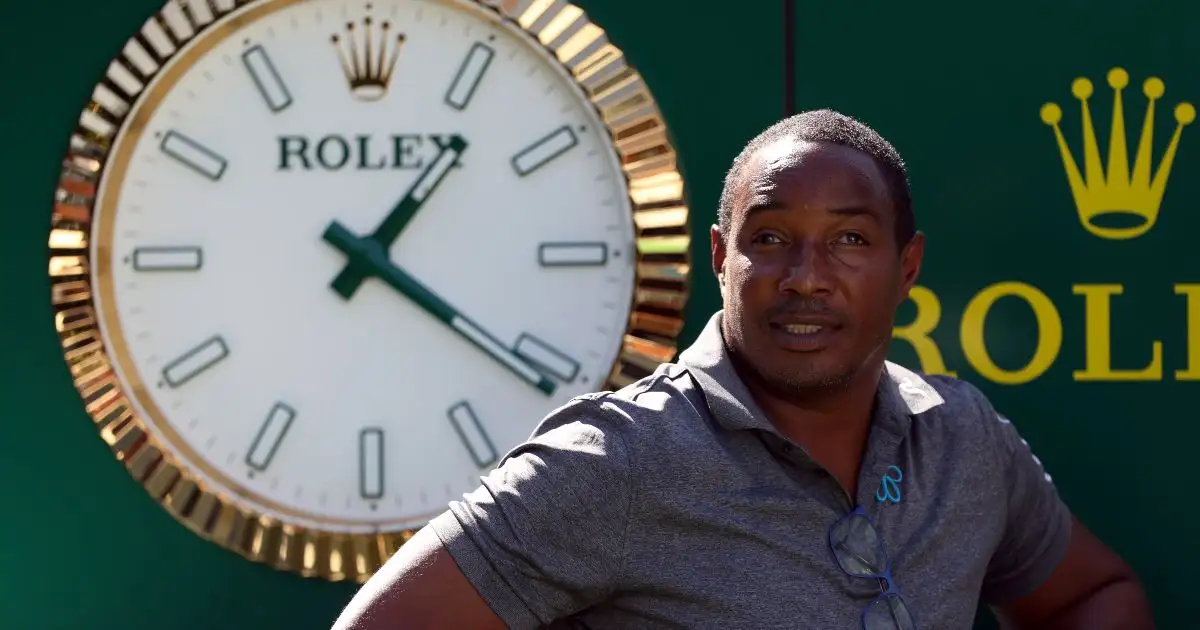 Former Man Utd midfielder Paul Ince stops in front of a clock