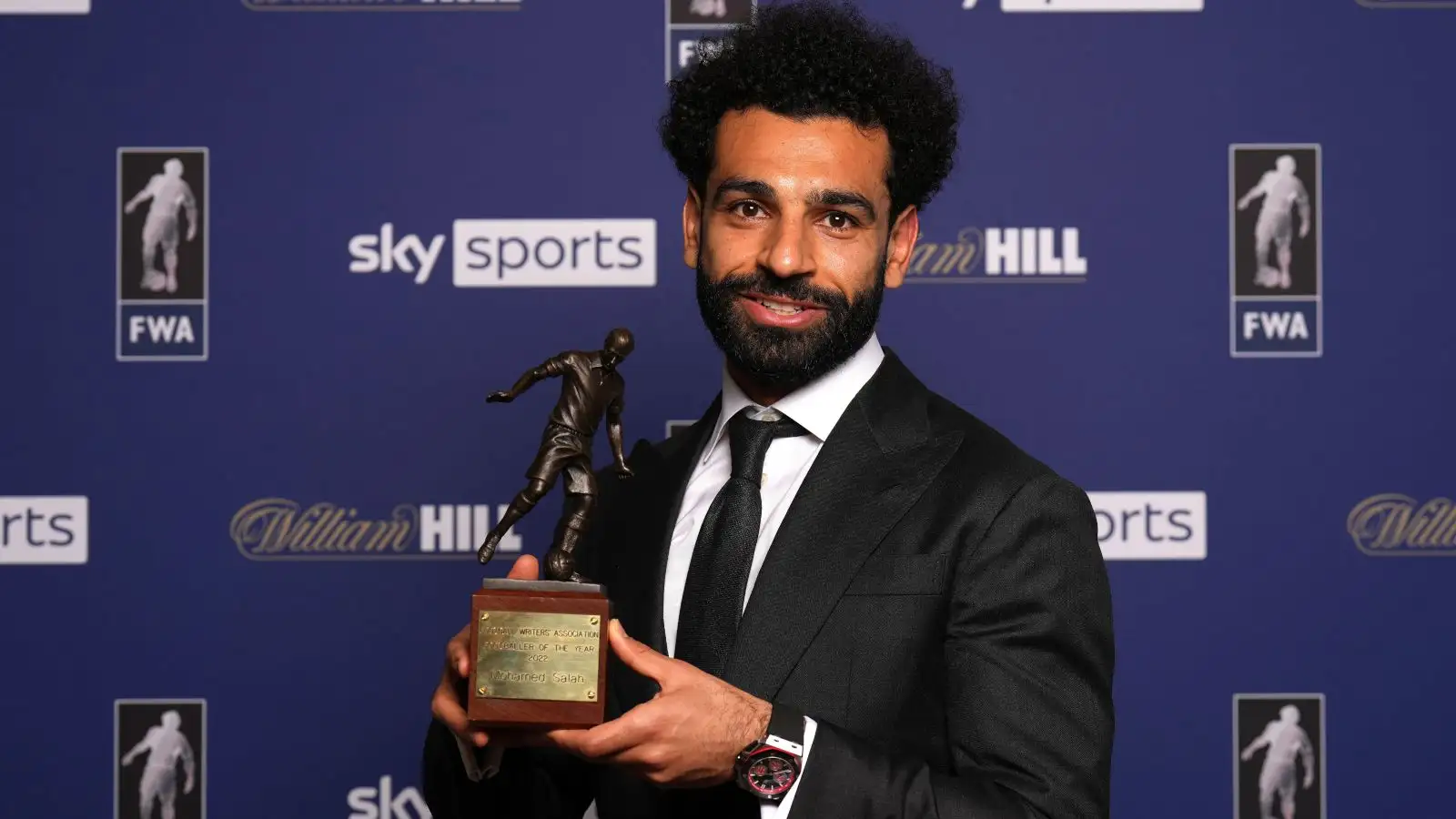 Liverpool striker Mo Salah holds the trophy