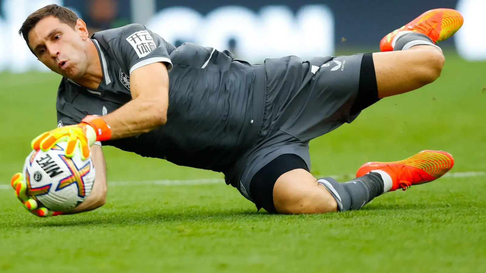 Aston Villa keeper Emiliano Martinez makes a diving save.