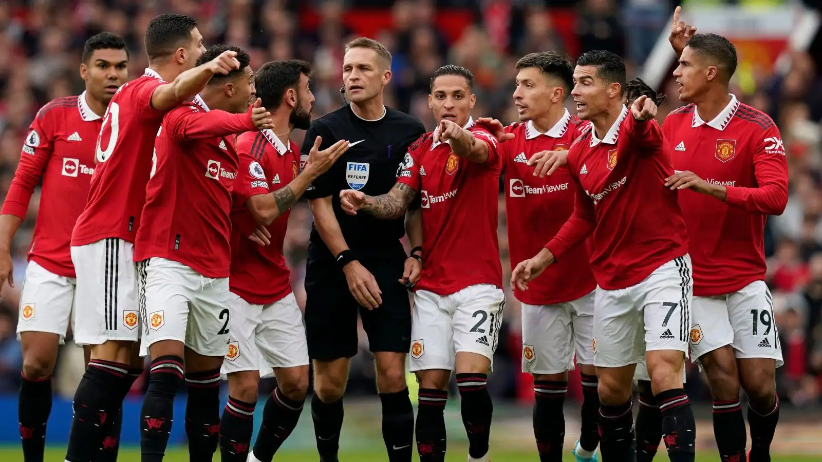 Man Utd players surround the referee