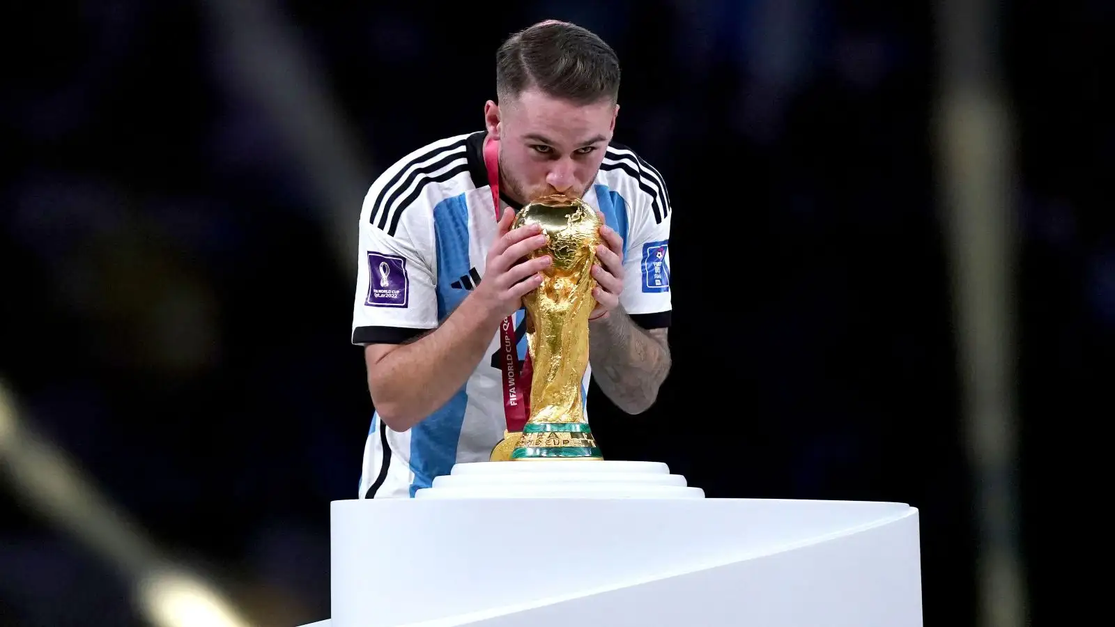 New Liverpool signing Alexis Mac Allister kisses the World Cup trophy.