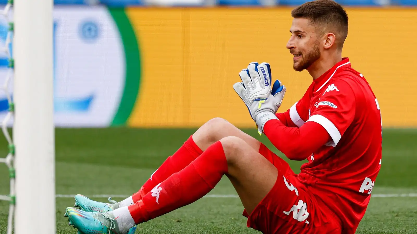 Empoli goalkeeper Guglielmo Vicario pleads with a referee while sat on the ground.