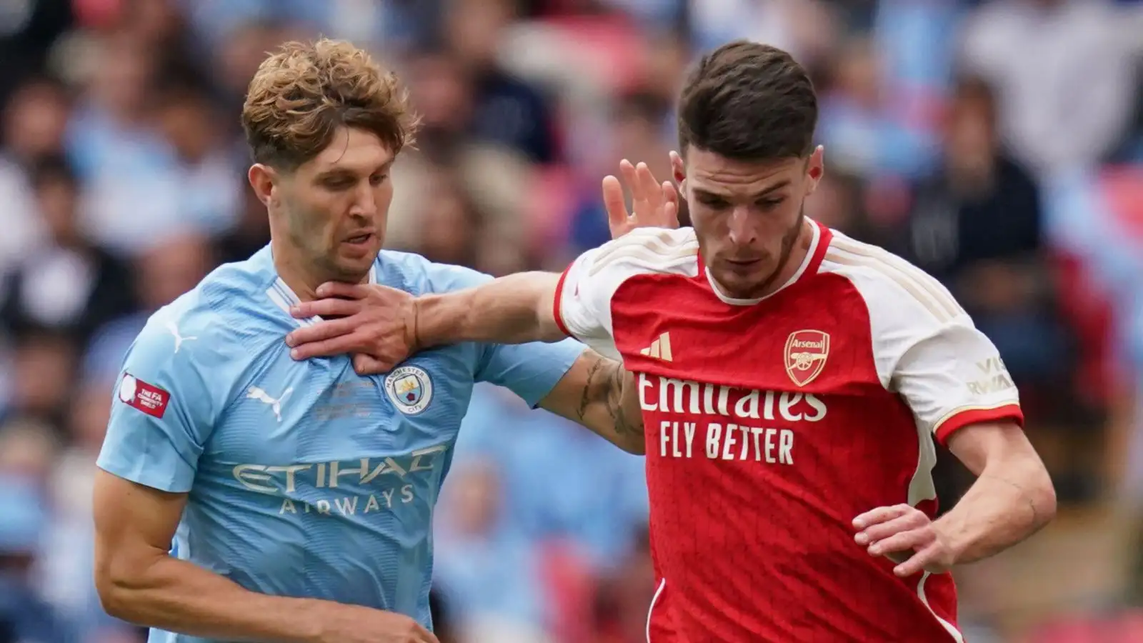 John Stones battles for the ball with Arsenal midfielder Declan Rice