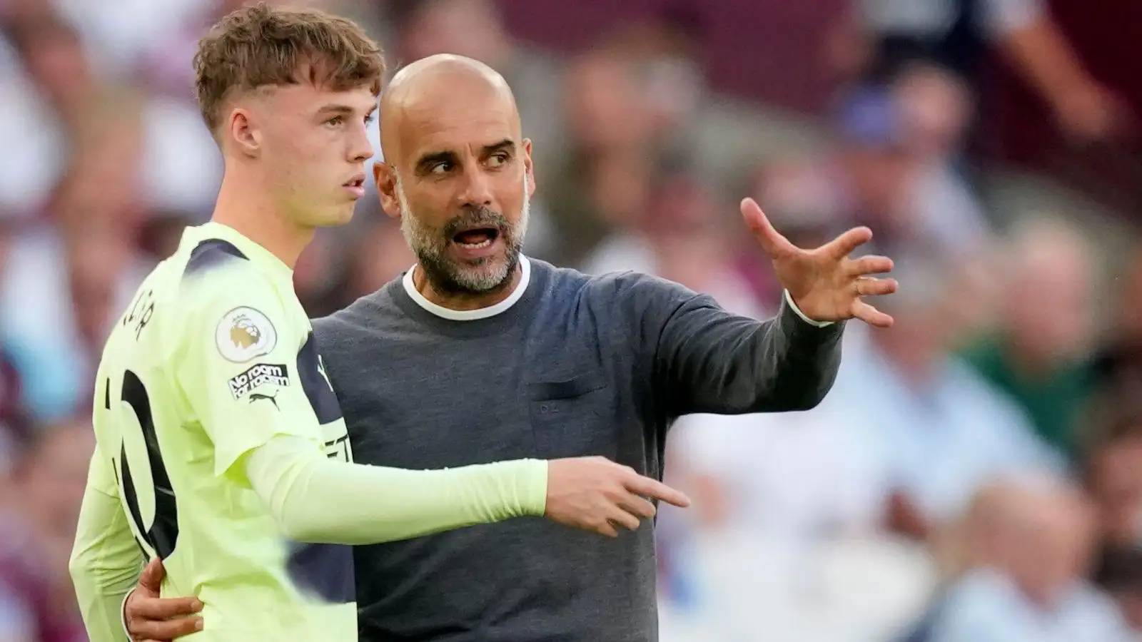 Pep Guardiola speaks to Cole Palmer during a Premier League match.