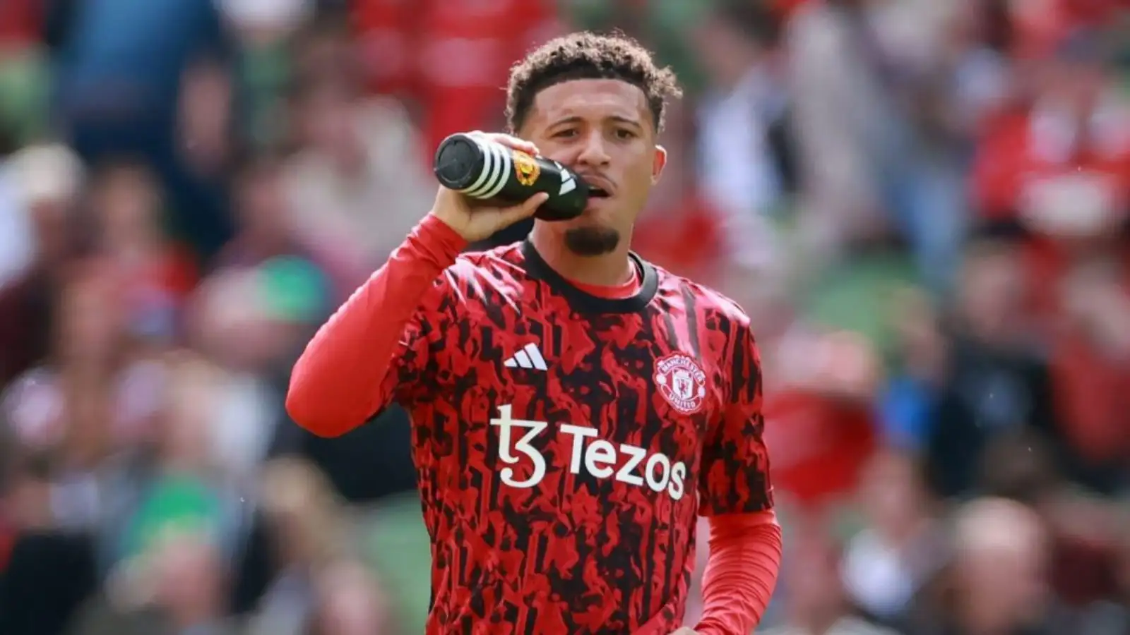 Manchester United winger Jadon Sancho drinks water during a pre-match warm-up.