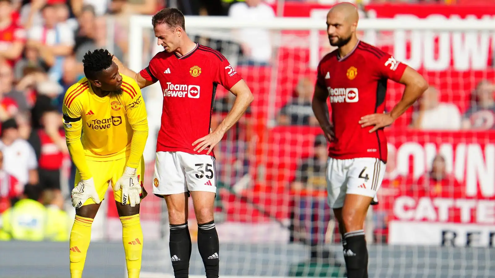 Manchester United players Sofyan Amrabat, Andre Onana and Jonny Evans look dejected after conceding a goal.