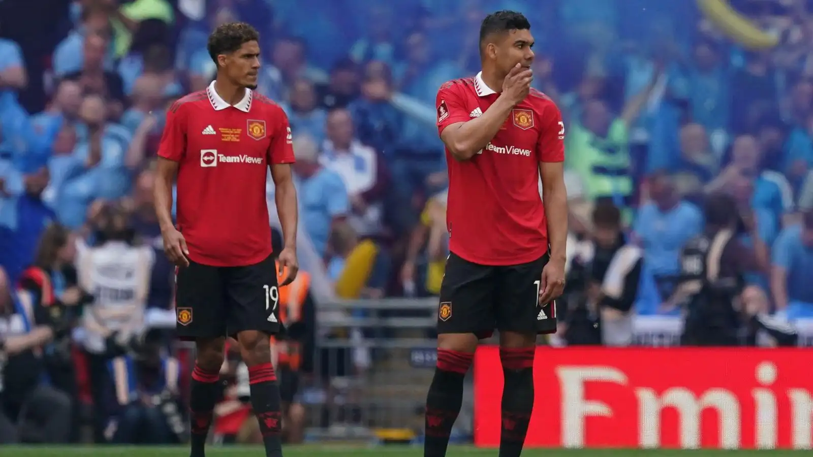 Casemiro and Raphael Varane look dejected in front of the Manchester City fans.