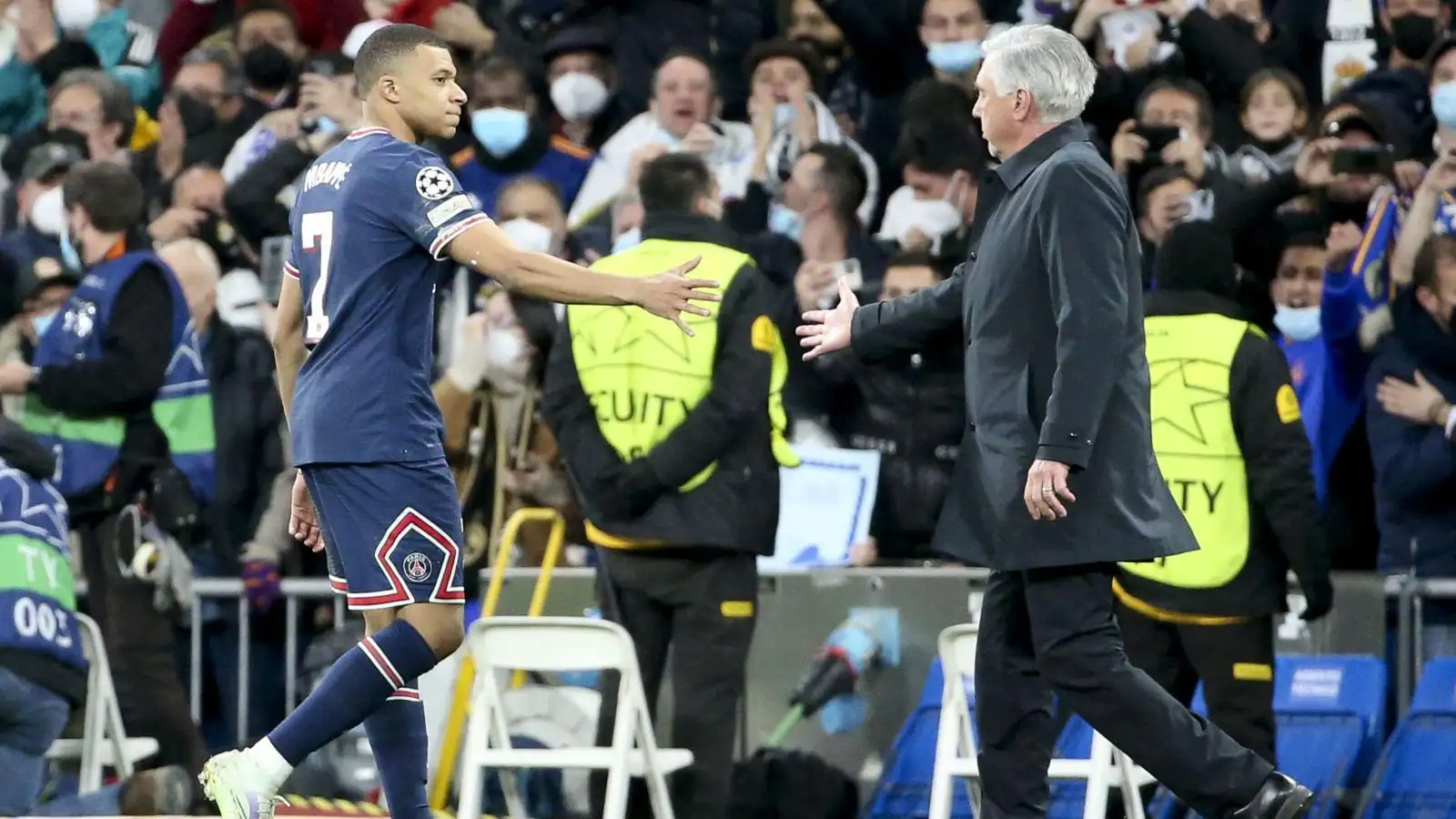 Carlo Ancelotti smoothies hands with Kylian Mbappe after a match.