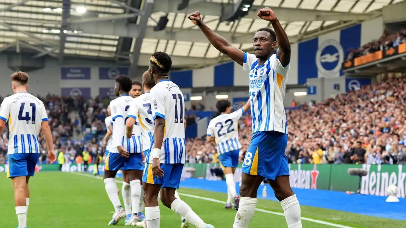 A crowd of Brighton players walk away from celebrating with Welbeck, who offers on last salutary arm-pump to the crowd