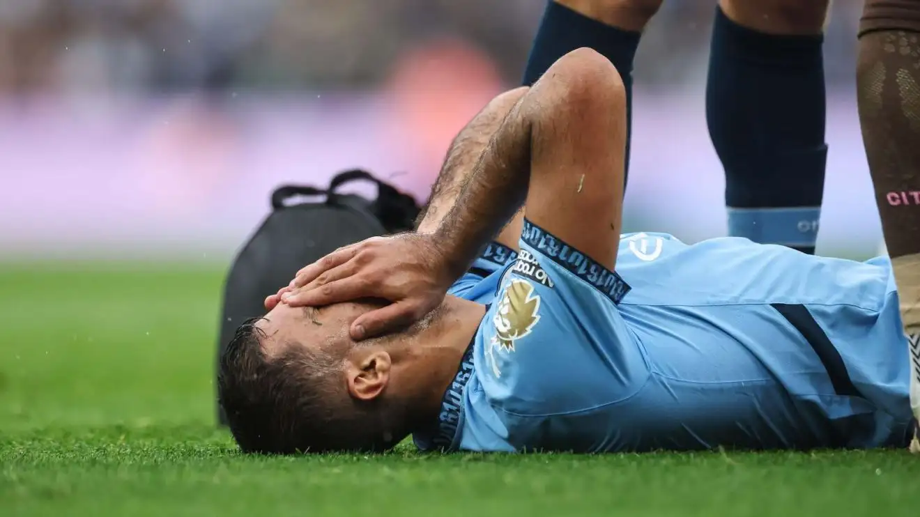 Male Municipal midfielder Rodri grasps his face in agony as he receives cure for an injury