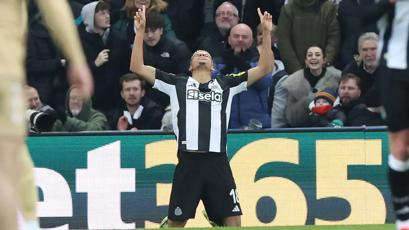 William Osula kneels and points to the sky with both hands after scoring against Bromley