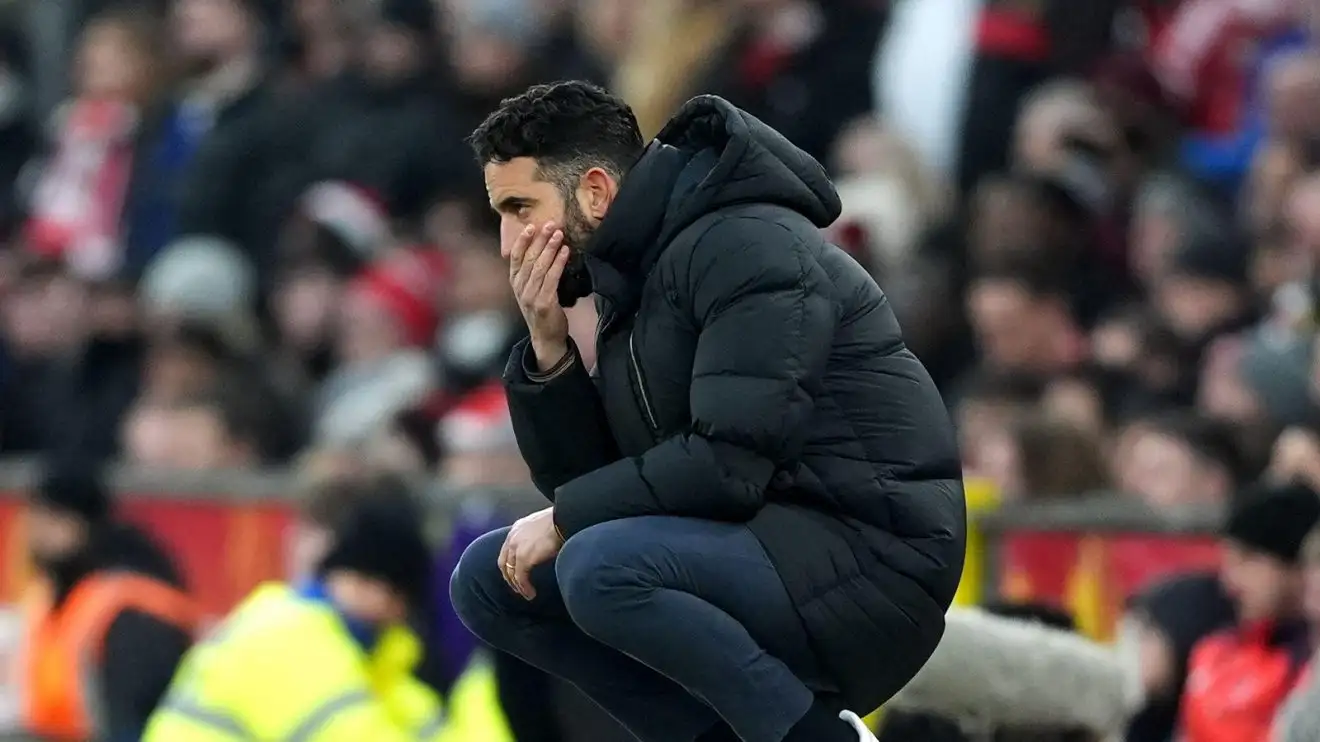 Ruben Amorim squats using his run away his mouth on the touchline