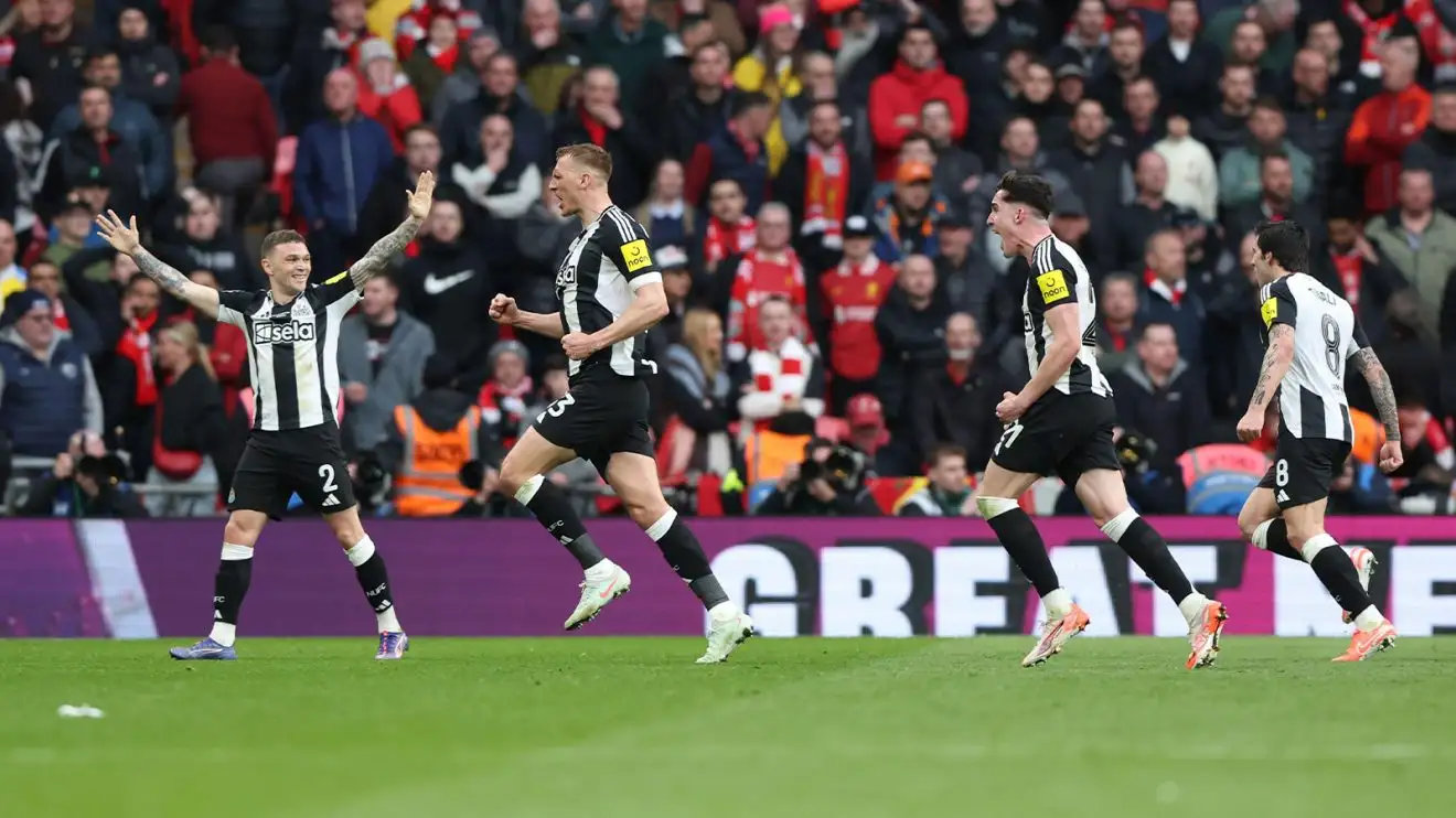 Dan Burn celebrates his goal with teammates as Liverpool fans look disconsolate in the background