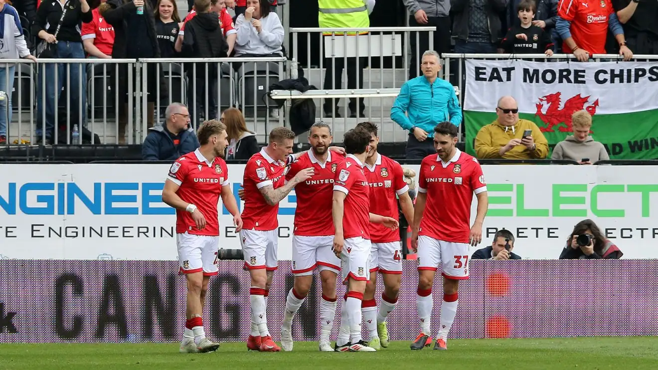 Wrexham players celebrate in front of fans during their victory over Stockport