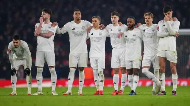 Arsenal player stand together during a penalty shootout