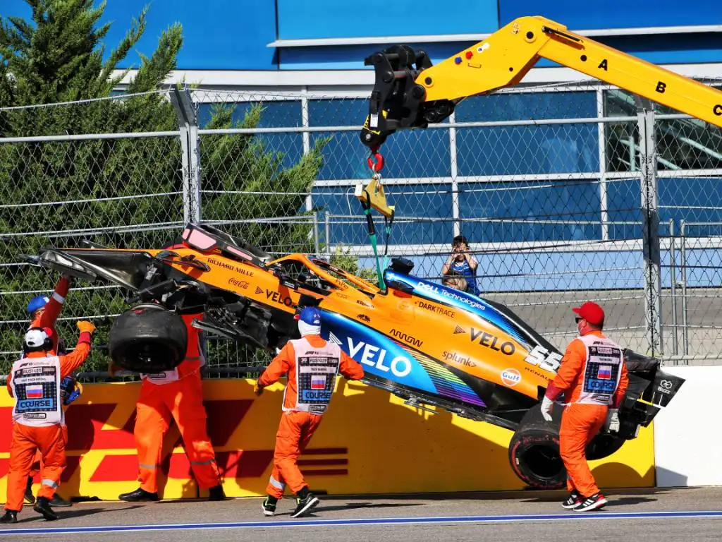 Carlos Sainz's McLaren is craned away after his accident in the Russian Grand Prix