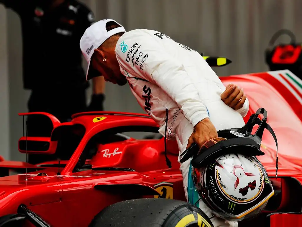 Lewis Hamilton looks into the Ferrari cockpit