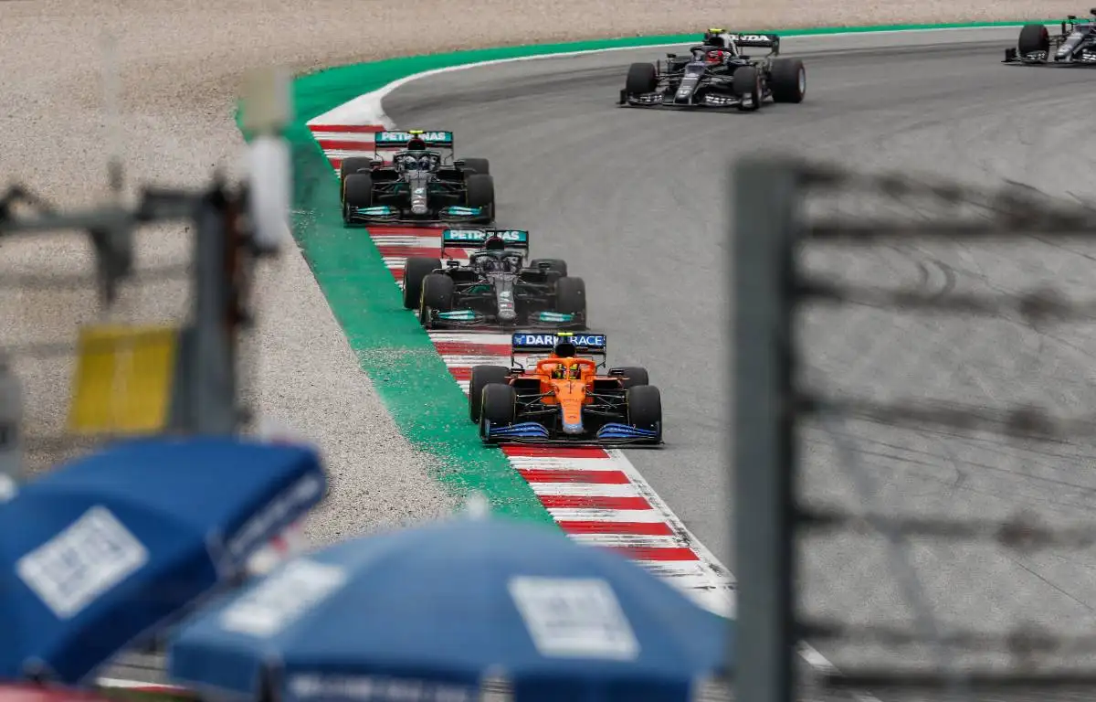 Lando Norris in his McLaren leads the two Mercedes cars of Lewis Hamilton and Valtteri Bottas
