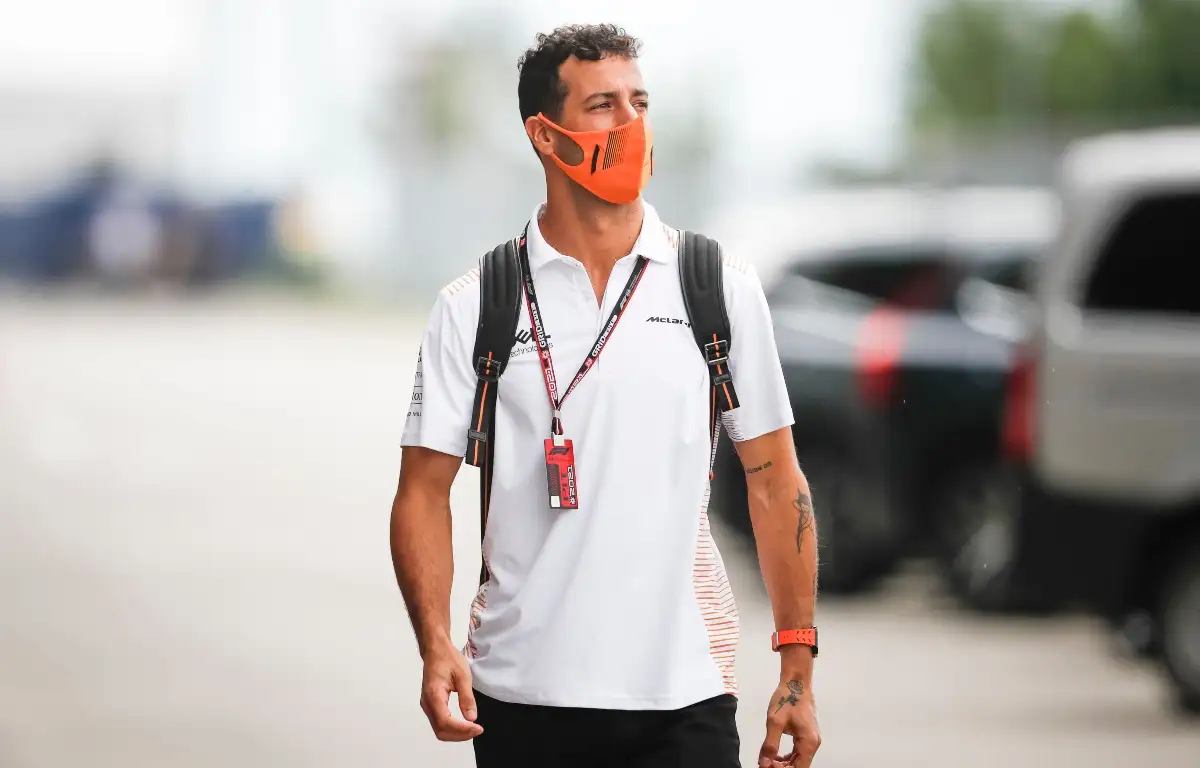 Daniel Ricciardo walks through the paddock.