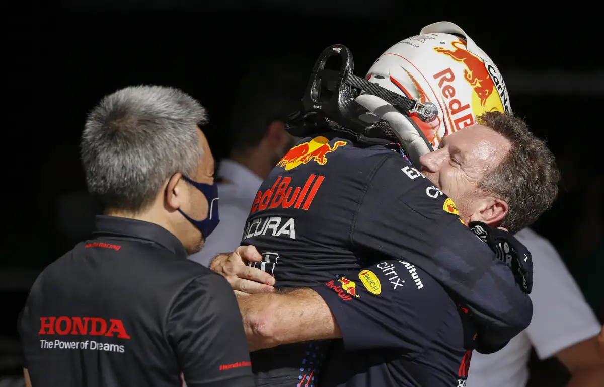 Christian Horner hugs Max Verstappen as Honda's Masashi Yamamoto watches. Austin October 2021