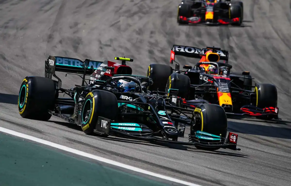 Mercedes driver Valtteri Bottas goes into Turn 1 ahead of Max Verstappen. Brazil November 2021.