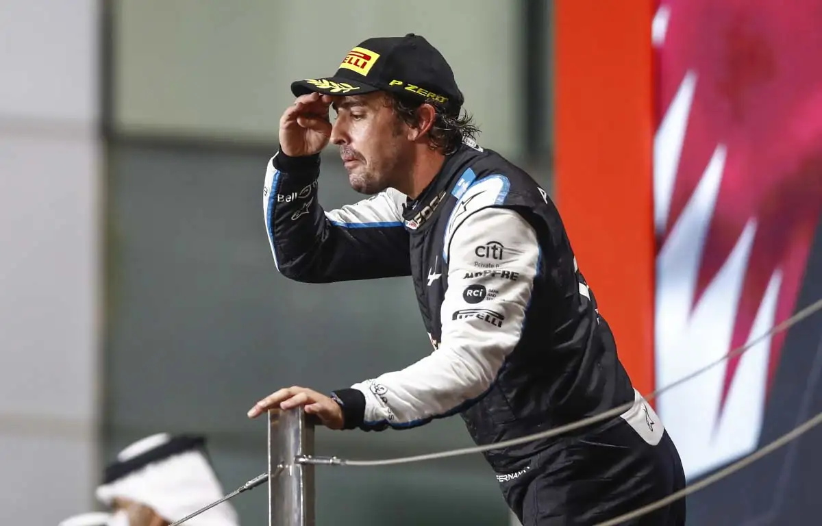 Fernando Alonso peers out over the podium. Qatar November 2021.