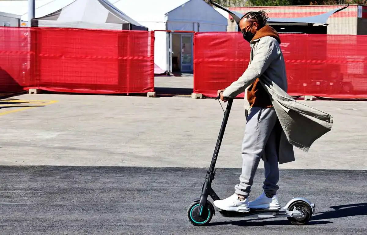Lewis Hamilton rides a scooter in the paddock. Barcelona February 2022.
