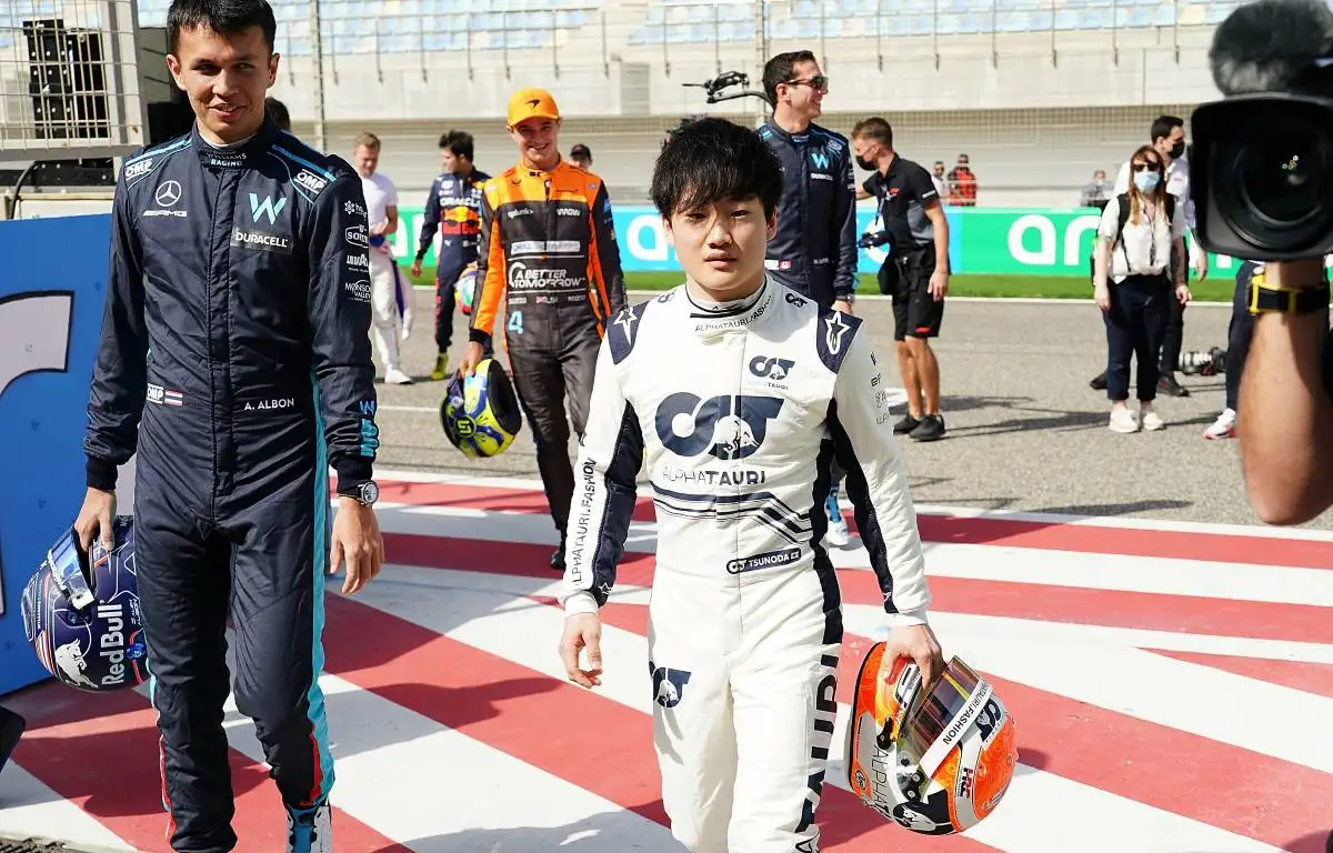 Yuki Tsunoda walking alongside Alex Albon. Bahrain March 2022.
