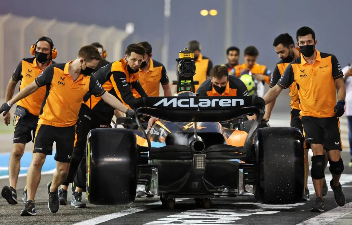 McLaren mechanics wheel the MCL36 back to the garage. Bahrain March 2022.