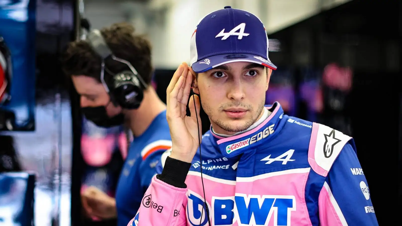 Alpine driver Esteban Ocon presses his earphone. Bahrain, March 2022.