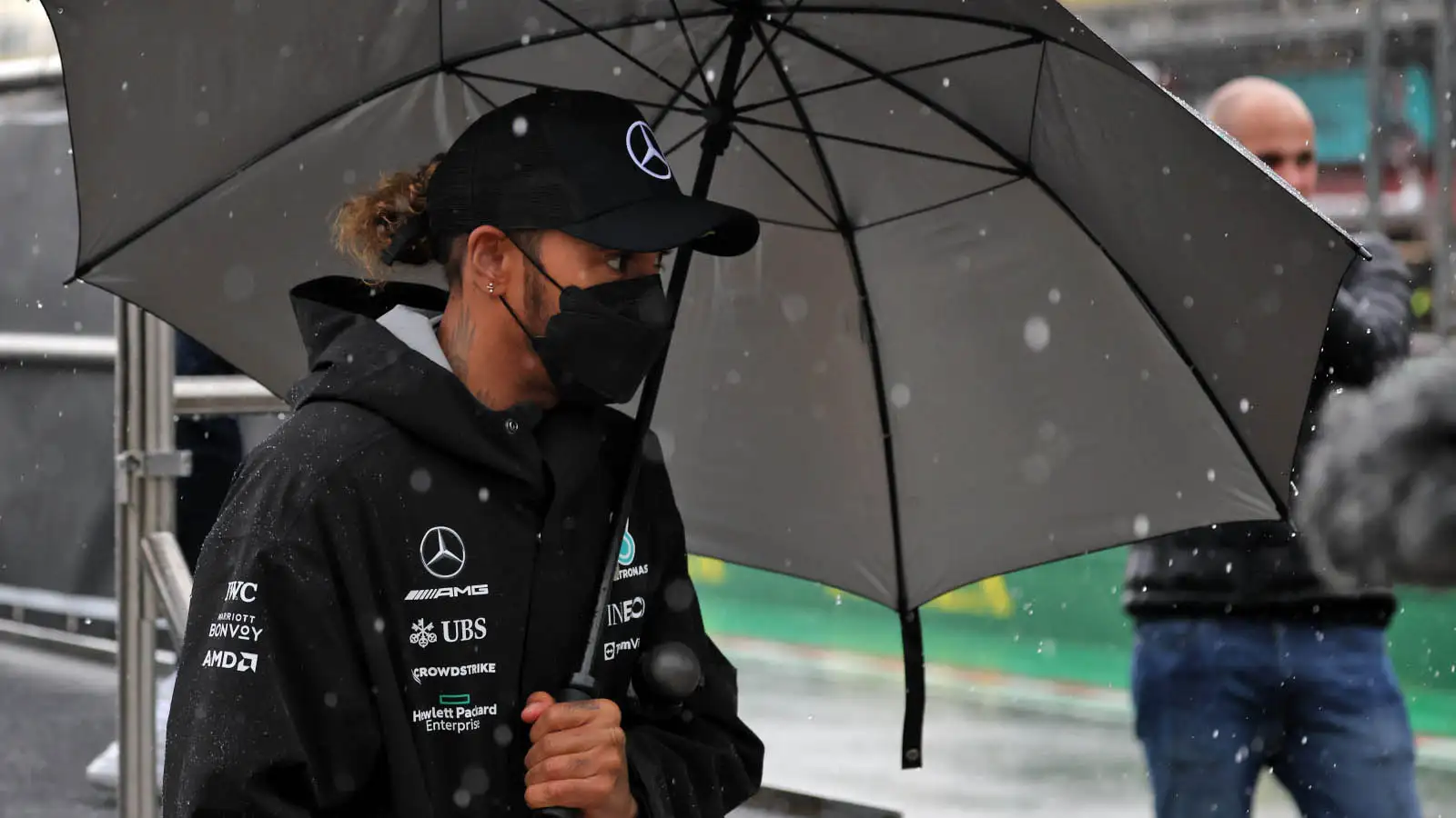 Lewis Hamilton shelters under an umbrella. Imola April 2022.
