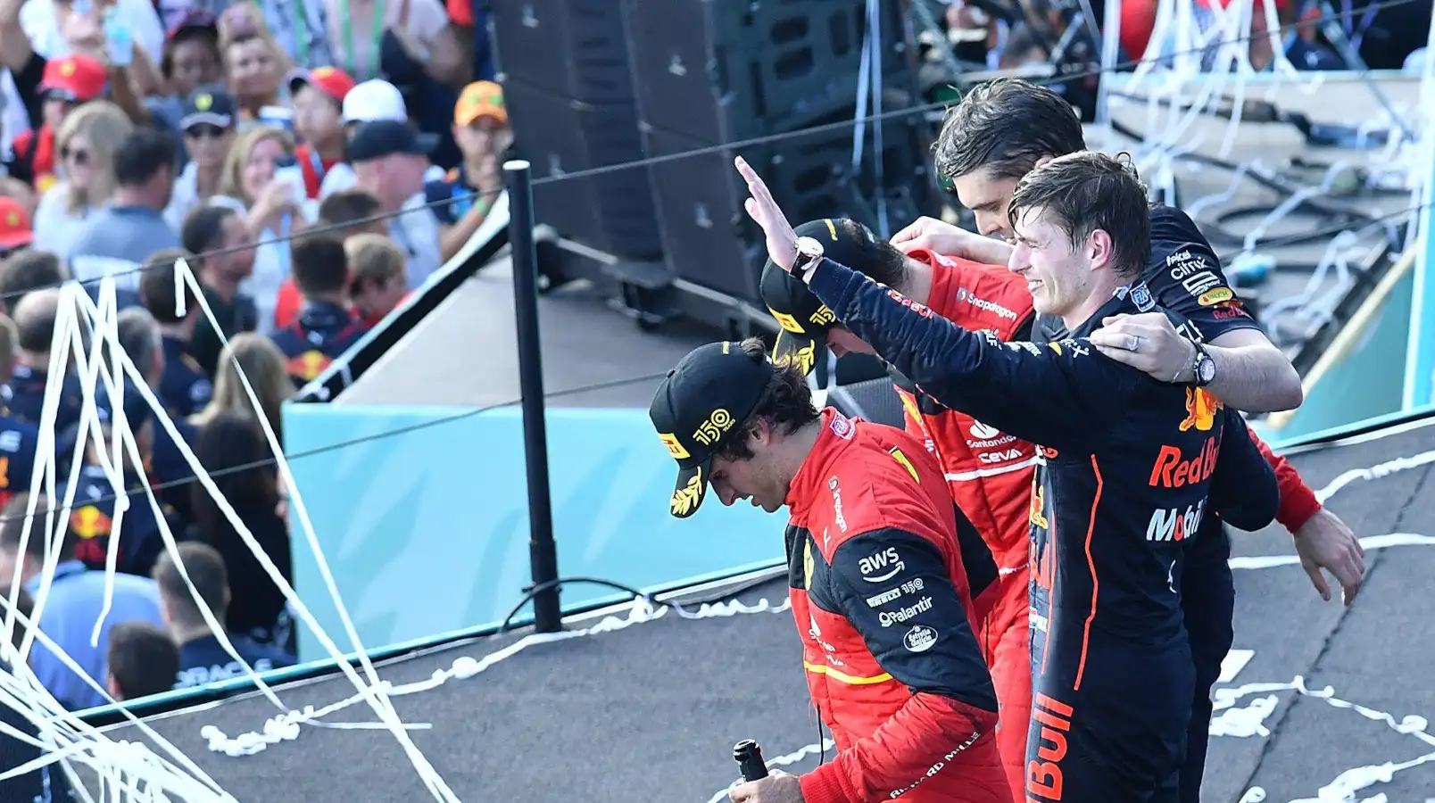 Max Verstappen arm raised on the podium with the Ferrari drivers. Miami May 2022