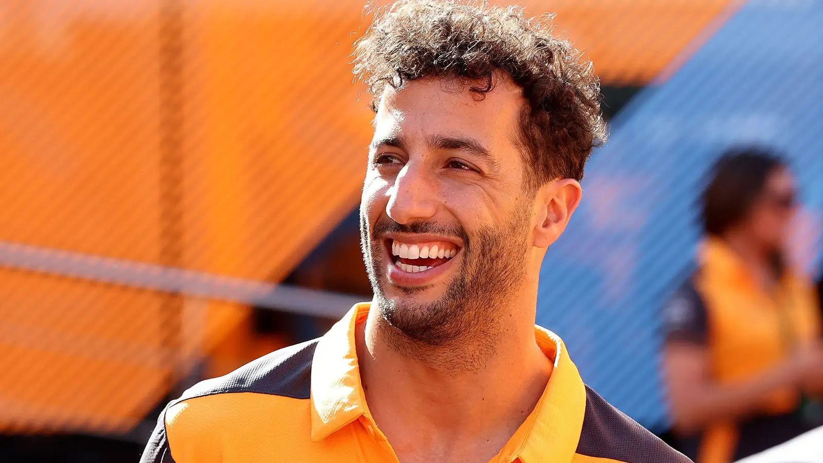Daniel Ricciardo smiling in the paddock in front of the McLaren motorhome. Spain May 2022