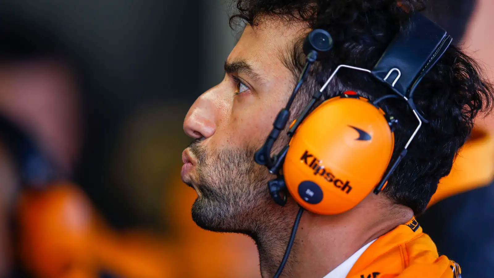 Daniel Ricciardo lips pursed as he watches the monitor. Monaco May 2022