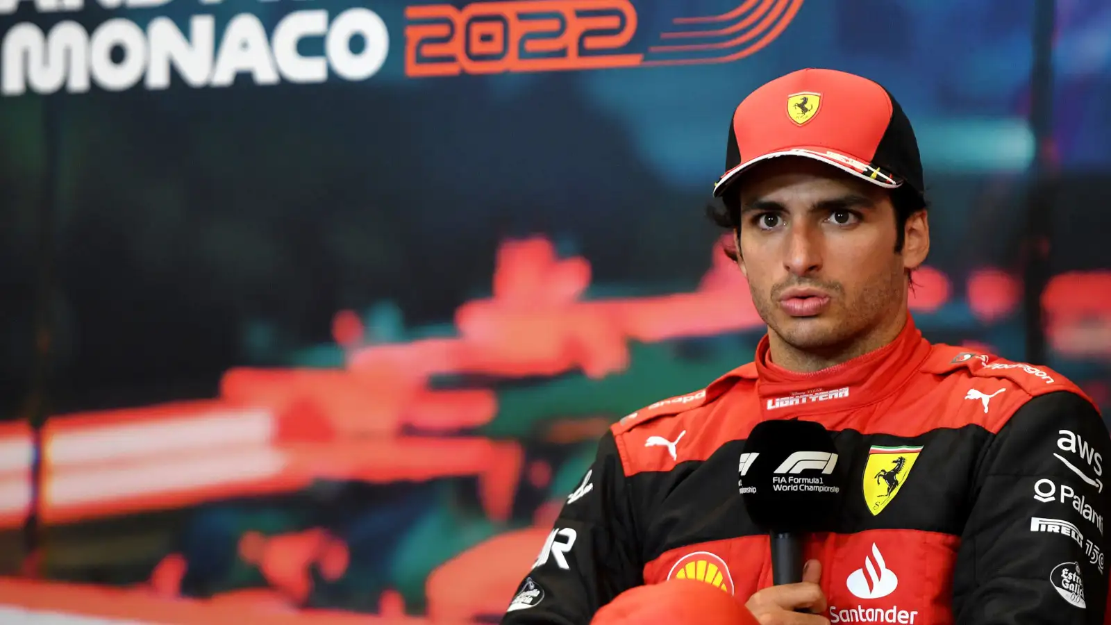 Carlos Sainz holding the mic as he speaks during the post-race press conference. Monaco May 2022