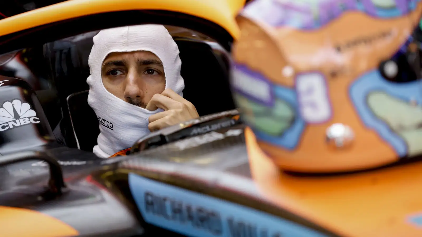Daniel Ricciardo in the car wearing fireproofs, helmet on the nose. Baku June 2022