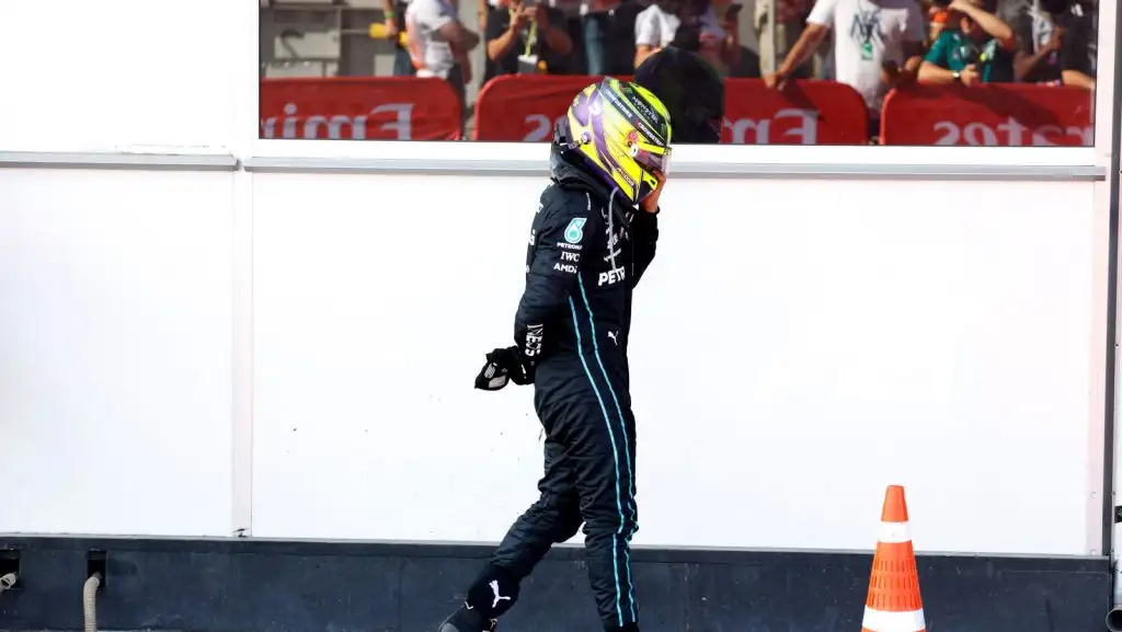 Lewis Hamilton walking away from his car holding his sore back. Baku June 2022