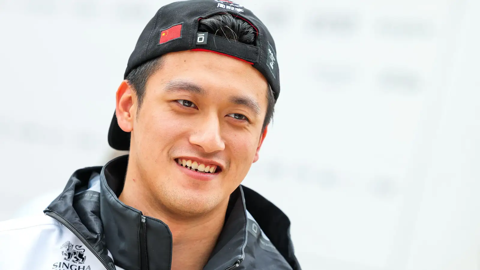 Zhou Guanyu with his cap on backwards, smiling. Britain July 2022