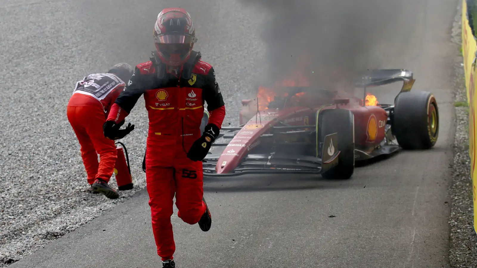 Ferrari's Carlos Sainz runs away from his burning car after engine failure. Spielberg, July 2022.
