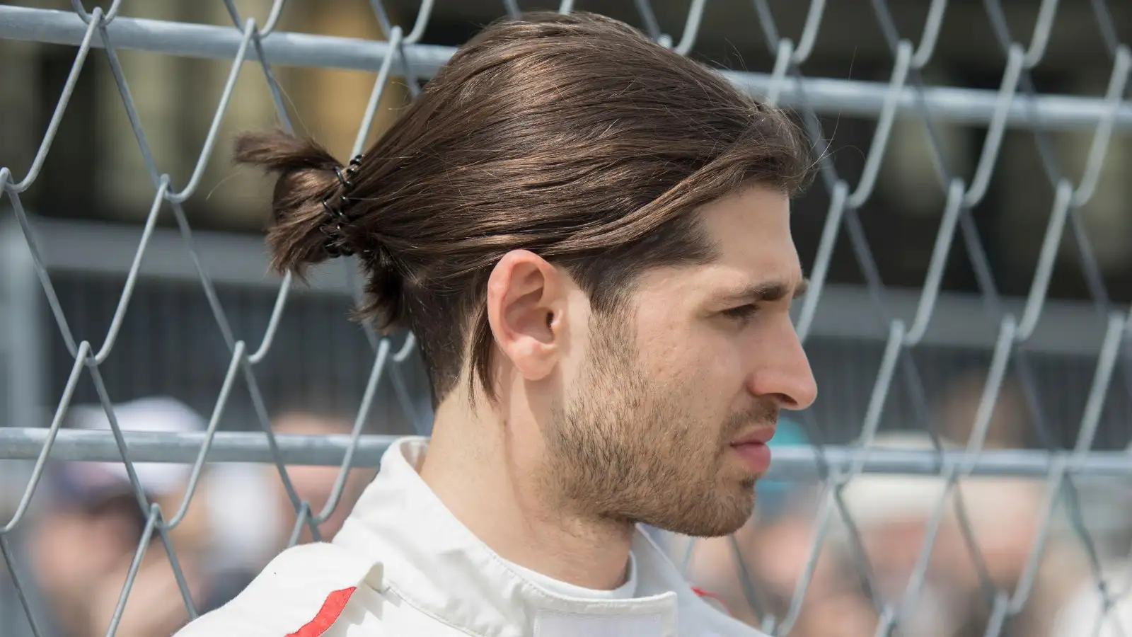 Formula E driver Antonio Giovinazzi stood near a fence. Germany, May 2022.
