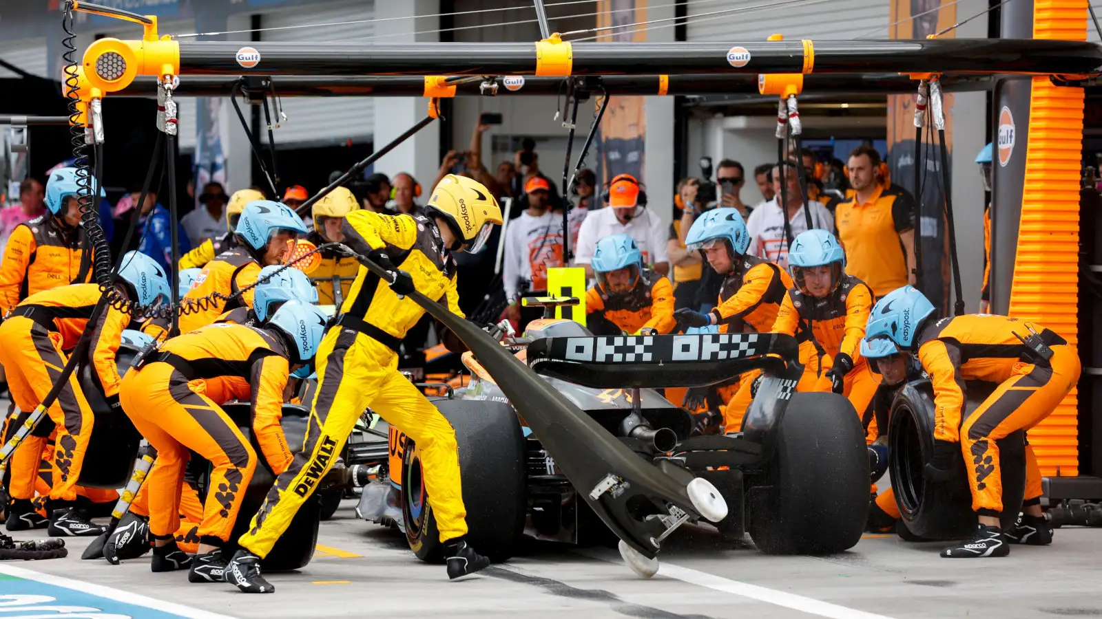 Lando Norris surrounded by McLaren mechanics in a pit stop. Miami May 2022