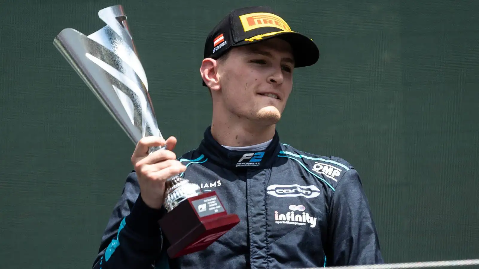 Logan Sargeant holds his trophy on the podium. Red Bull Ring July 2022.
