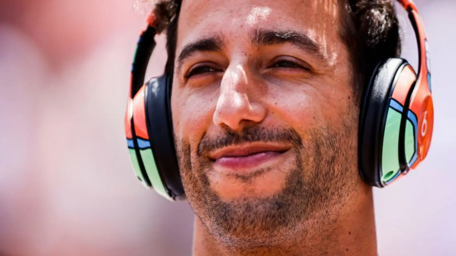 Daniel Ricciardo with a smile as he listens to music with headphones on. Monaco May 2022
