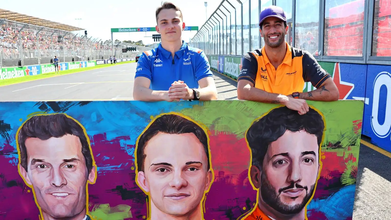 Oscar Piastri and Daniel Ricciardo standing with a mural. Melbourne April 2022.