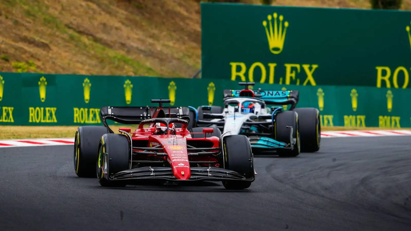 Charles Leclerc's Ferrari ahead of a Mercedes during the Hungarian GP. Hungaroring July 2022.