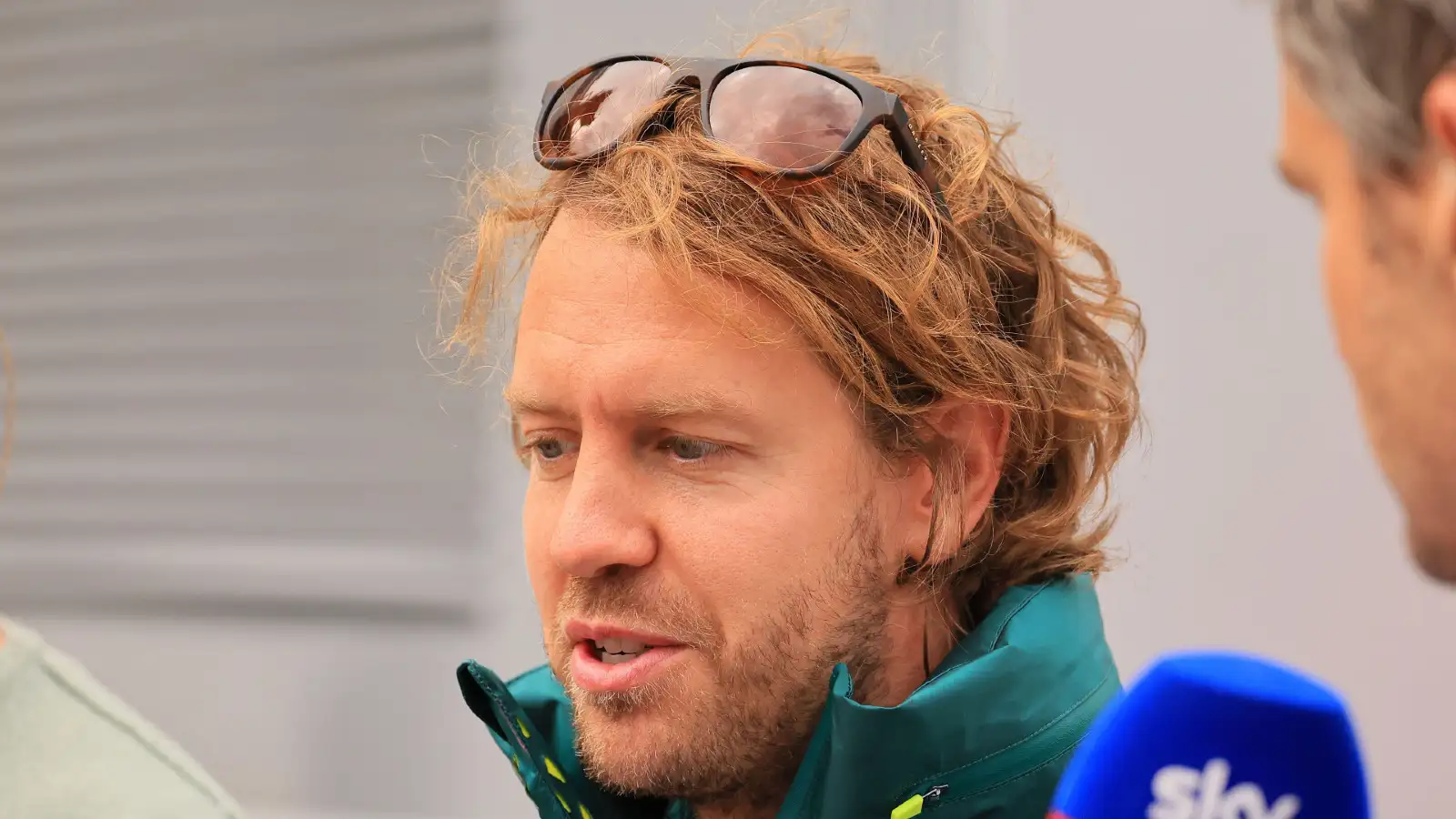 Sebastian Vettel with sunglasses on his head, conducting an interview. Hungaroring July 2022.