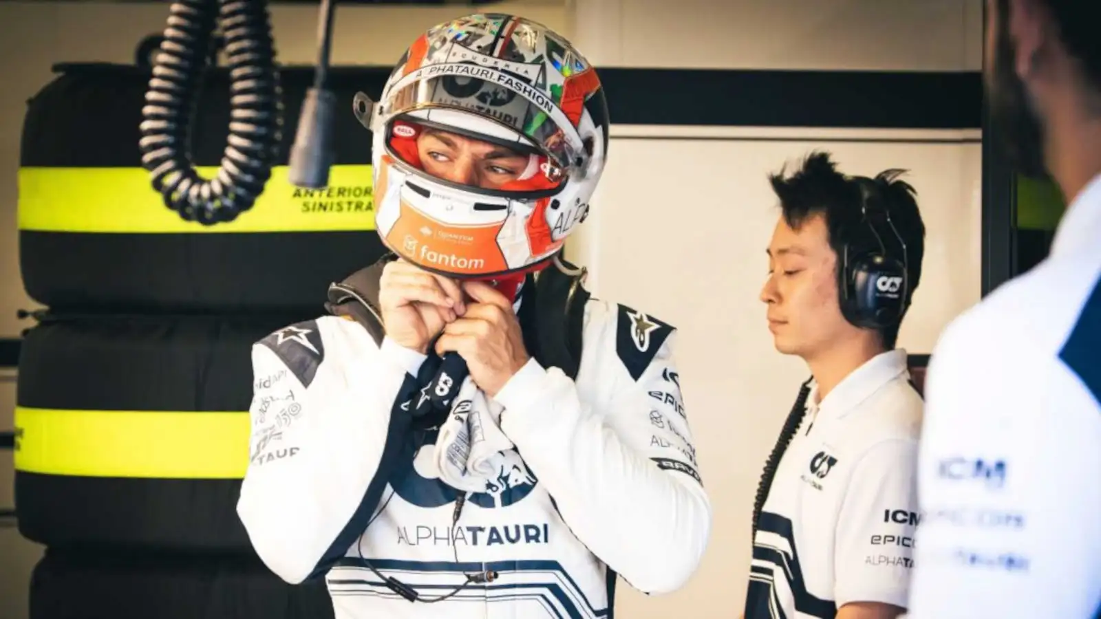 Pierre Gasly putting on his helmet while standing in the team's garage. Baku June 2022