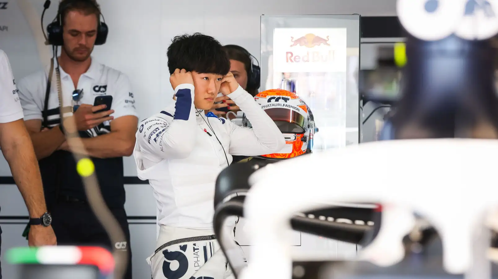 Yuki Tsunoda putting in his ear plugs in the garage. France July 2022