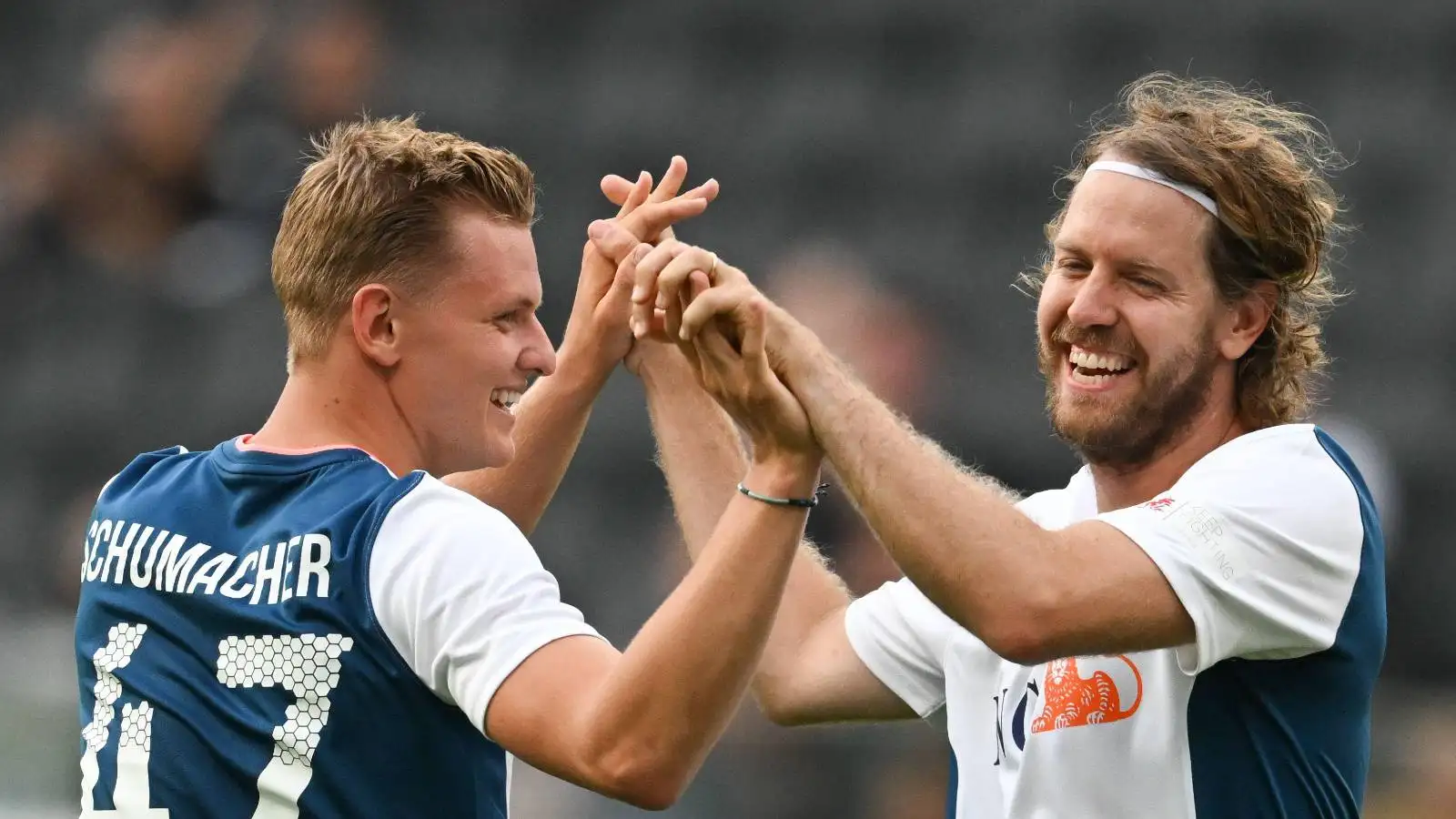 Mick Schumacher and Sebastian Vettel high five at a charity football game. Germany, August 2022.