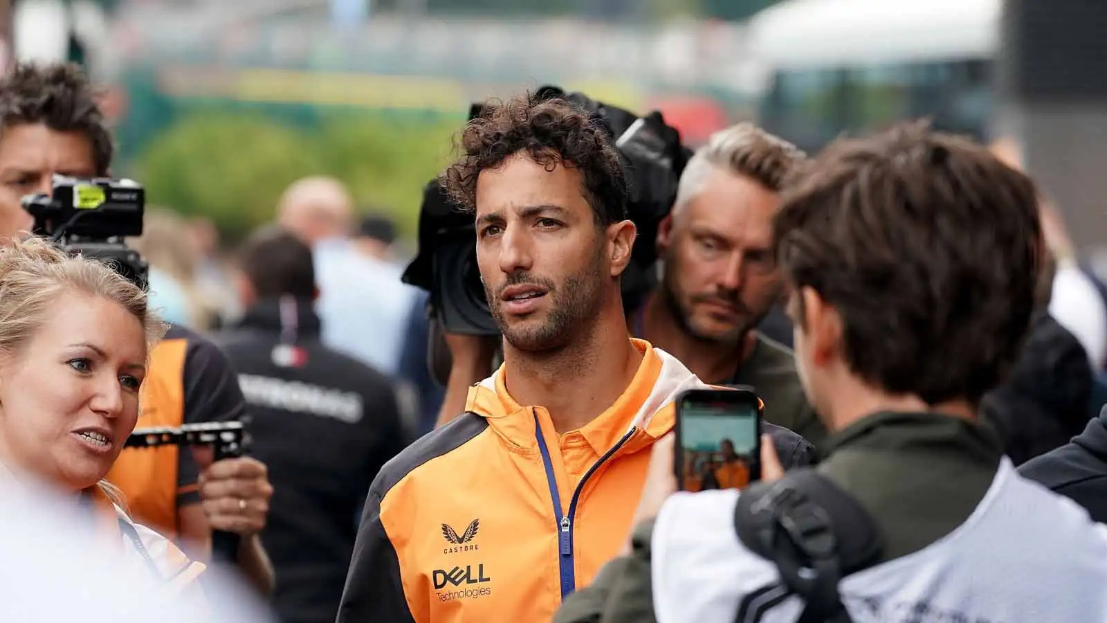 Daniel Ricciardo walks through a crowd. Spa August 2022.